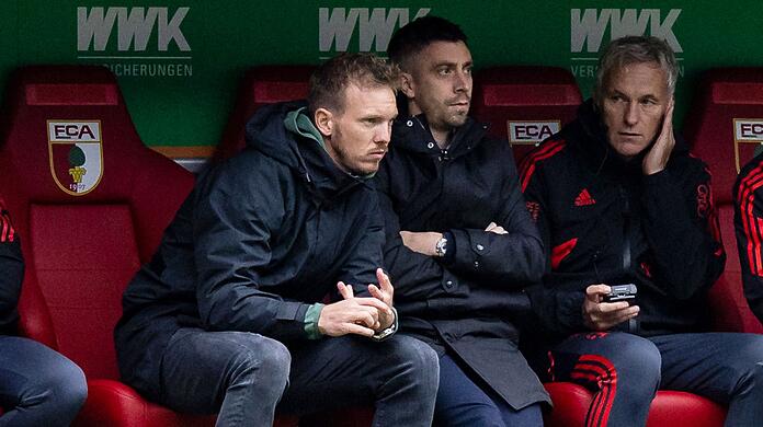 Münchens Trainer Julian Nagelsmann (l) sitzt auf der Trainerbank.