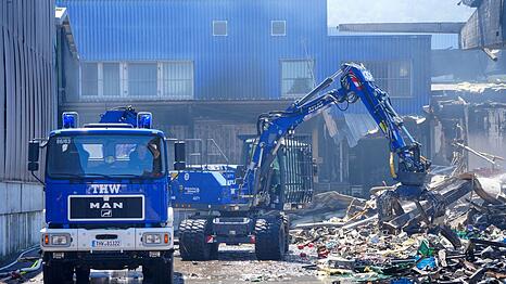 Einsatzkr&auml;fte des Technischen Hilfswerks (THW) beseitigen mit einem Bagger Schutt nach dem Feuer in einem Gewerbegebiet in Stuttgart.