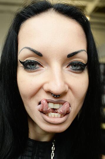 Ihre gespaltene Zunge zeigt Aneta Von Cyborg bei einer Tattoo-Messe in der Old Truman Brauerei in London.