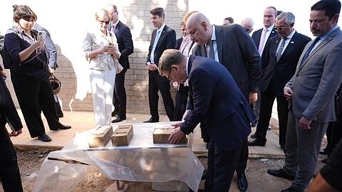 Außenminister Johann Wadephul (CDU) macht sich ein Bild von einem Projekt, das Binnenvertriebenen ermöglichen soll, günstig mit Lehmziegeln zu bauen.