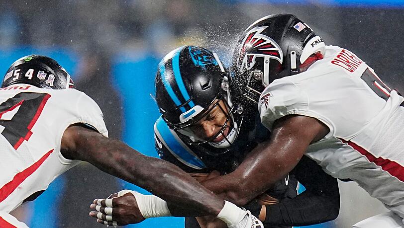 Carolina Panthers Chuba Hubbard (M) wird von Atlanta Falcons Rashaan Evans (l) und Lorenzo Carter angegriffen.