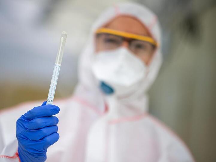 Ein Mitarbeiter hält in einem Abstrichzentrum einen Coronatest-Abstrich in der Hand. Foto: Sebastian Gollnow/dpa/Symbolbild