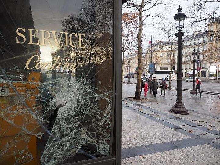 Eine zerborstene Glasscheibe eines Lokals auf der Pariser Prachtstraße Champs-Elysees.