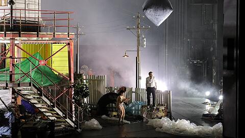 Schaut aus wie im Bayreuther Castorf-"Ring": Komödiant Michael Nagy als Ratefreund im weißen Hemd und ein komischer Vogel auf der Bühne von Aleksandar Denic im Nationaltheater.
