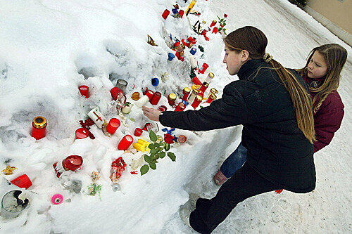Zwei Mädchen entzünden am Mittwoch (4. Januar 2006) auf dem Rathausplatz von Bad Reichenhall Kerzen.