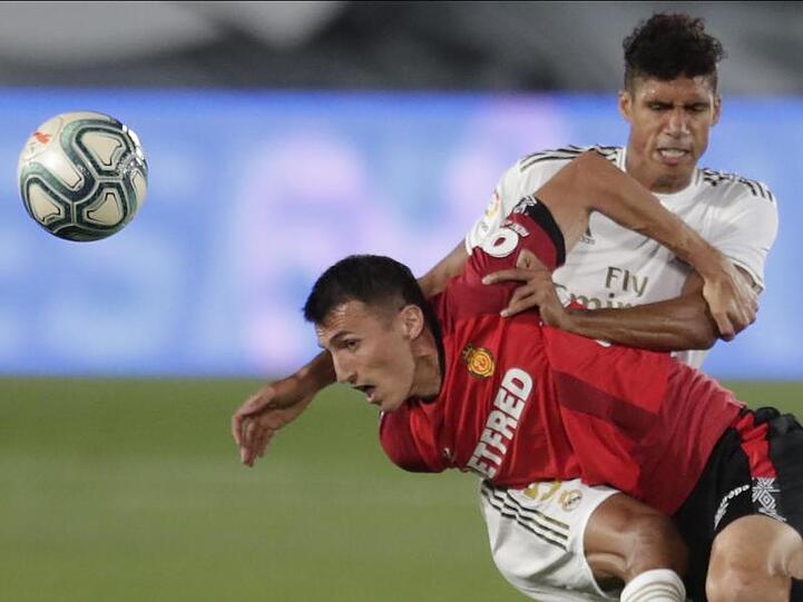 Raphael Varane (r) von Real Madrid kämpft gegen Ante Budimir (l) vom RCD Mallorca um den Ball.