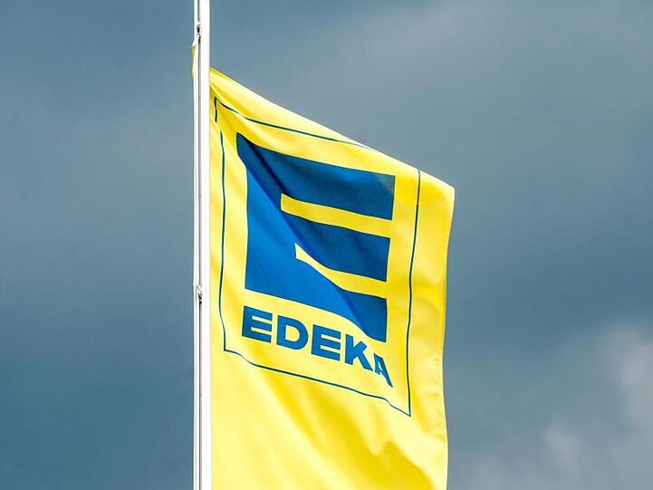 Eine Fahne mit dem Logo von Edeka ist zu sehen. Foto: Armin Weigel/Archiv