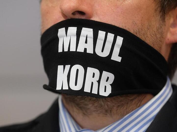Sven Liebich trägt im Gerichtssaal in Halle einen Mundschutz mit der Aufschrift "Maulkorb".