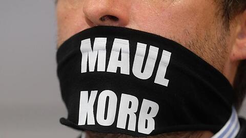 Sven Liebich trägt im Gerichtssaal in Halle einen Mundschutz mit der Aufschrift "Maulkorb".