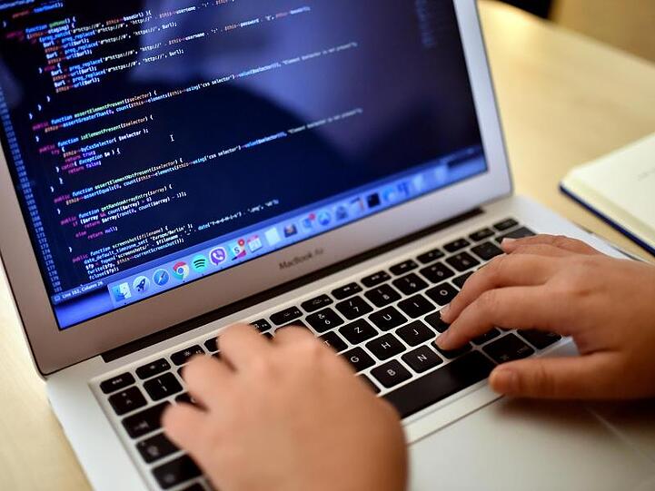 Eine Teilnehmerin arbeitet in Berlin bei einem Programmierkurs an einem Laptop.
