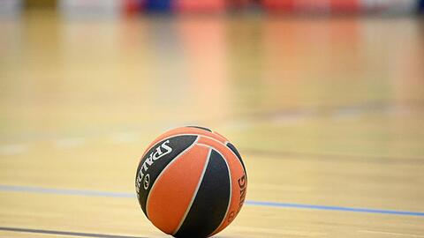 Ein Ball liegt auf einem Basketball-Spielfeld.