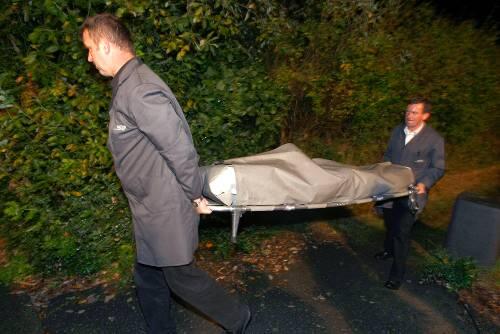 Eines der Opfer wird nach dem Dreifachmord im Schrebergarten im Zinksarg weggetragen
