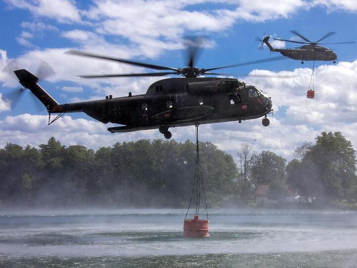Auftanken: Hubschrauber der Bundeswehr nehmen jeweils 5000 Liter Löschwasser in einem See auf.