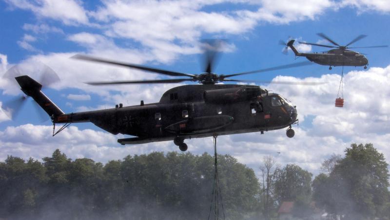 Auftanken: Hubschrauber der Bundeswehr nehmen jeweils 5000 Liter Löschwasser in einem See auf.