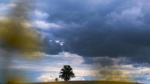Regenwolken ziehen über die Landschhaft bei Höhenrain im Landkreis Starnberg. Foto: Stephan Jansen/dpa/Archivbild