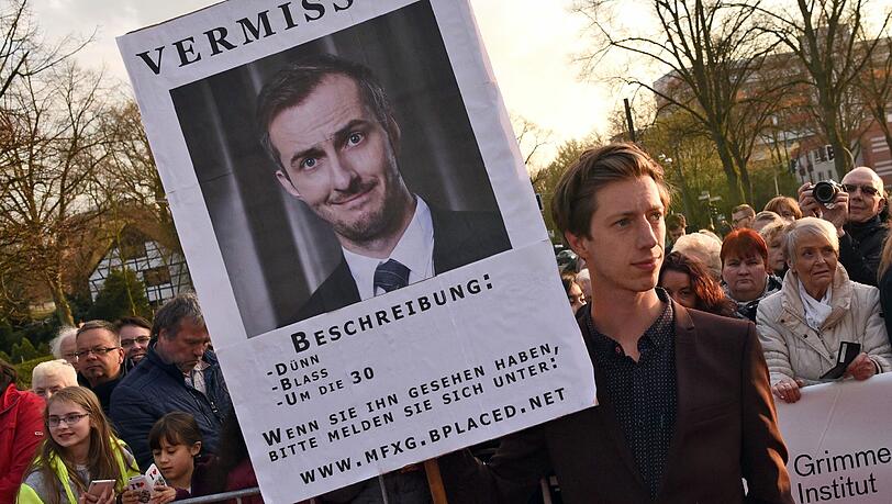 Der Schauspieler Max Mauff hält eine Plakat mit der Aufschrift «Vermisst», das auf die Abwesenheit des Satirikers Jan Böhmermann hin weist. Auch die Grimme-Direktorin sprach sich für Böhmermann aus. Der Schauspieler Max Mauff hält eine Plakat mit der Aufschrift «Vermisst», das auf die Abwesenheit des Satirikers Jan Böhmermann hin weist. Auch die Grimme-Direktorin sprach sich für Böhmermann aus.