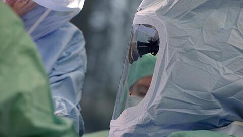 Ein Mediziner-Team trägt Schutzkleidung während der Operation. Foto: picture alliance / dpa/Archivbild