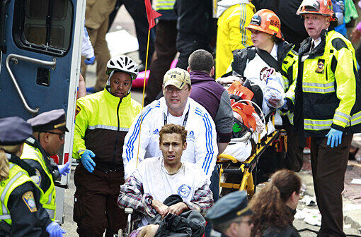 Anschlag auf den Marathon von Boston: Ein verletzter Läufer wird in einem Rollstuhl geschoben.