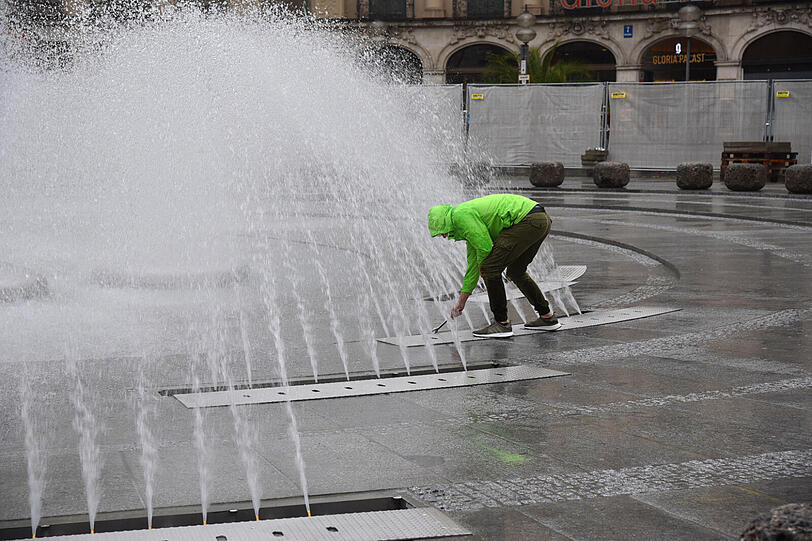 Mitarbeiter der Stadt überprüfen die Wasserdüsen.