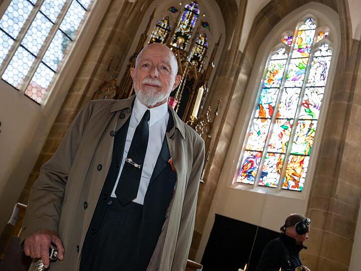 Markus Lüpertz steht in der Bamberger St. Elisabeth-Kirche vor einem von ihm gestalteten Fenstern (r). Foto: Daniel Karmann