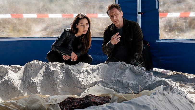 "Dünentod - Ein Nordsee-Krimi": Ceylan (Yasemin Cetinkaya) und Tjark (Hendrik Duryn) untersuchen die Gräber der Opfer. "Dünentod - Ein Nordsee-Krimi": Ceylan (Yasemin Cetinkaya) und Tjark (Hendrik Duryn) untersuchen die Gräber der Opfer.