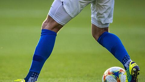 Ein Fußballspieler ist am Ball.