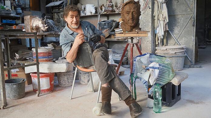 Der Münchner Künstler Nikolai Tregor bei seiner täglichen Arbeit an der Helmut-Dietl-Skulptur.
