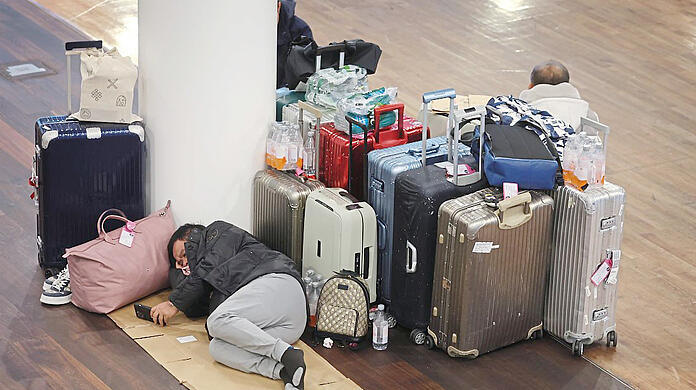 2. Dezember am Flughafen München: Ein Passagier schläft auf dem wegen Schneechaos gesperrten Airport.