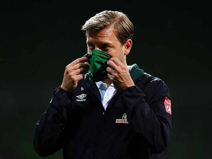 Werder-Trainer Florian Kohfeldt geht nach dem Spiel mit Maske vom Platz.