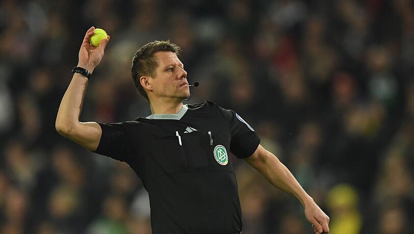 Schiedsrichter Patrick Ittrich wirft einen Tennisball vom Spielfeld.