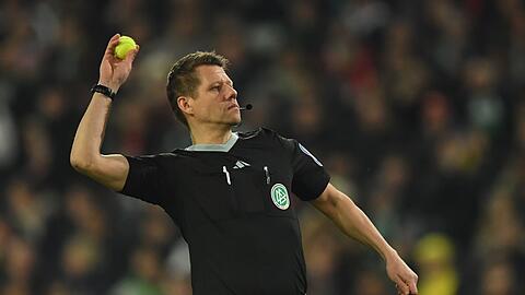 Schiedsrichter Patrick Ittrich wirft einen Tennisball vom Spielfeld.