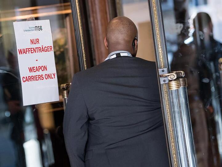 Ein Mann betritt das Tagungshotel durch einen Eingang mit der Aufschrift "Nur Waffenträger". Zu dem wichtigsten sicherheitspolitischen Expertentreffen weltweit haben sich rund 30 Staats- und Regierungschefs sowie etwa 90 Minister angekündigt.