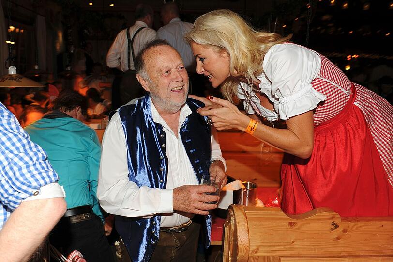 Regisseur Joseph Vilsmaier ratscht mit Freundin Birgit, die im roten Dirndl eine gute Figur macht.