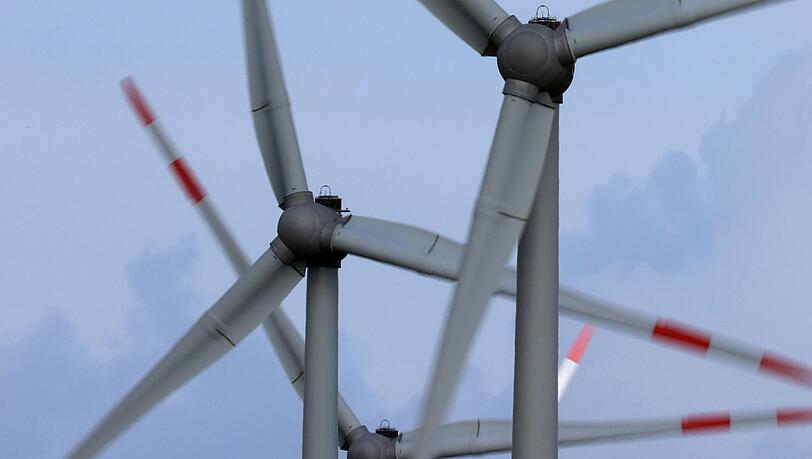 Windräder drehen sich auf einem Feld im Wind.