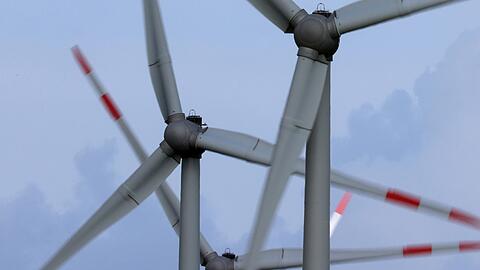 Windräder drehen sich auf einem Feld im Wind.