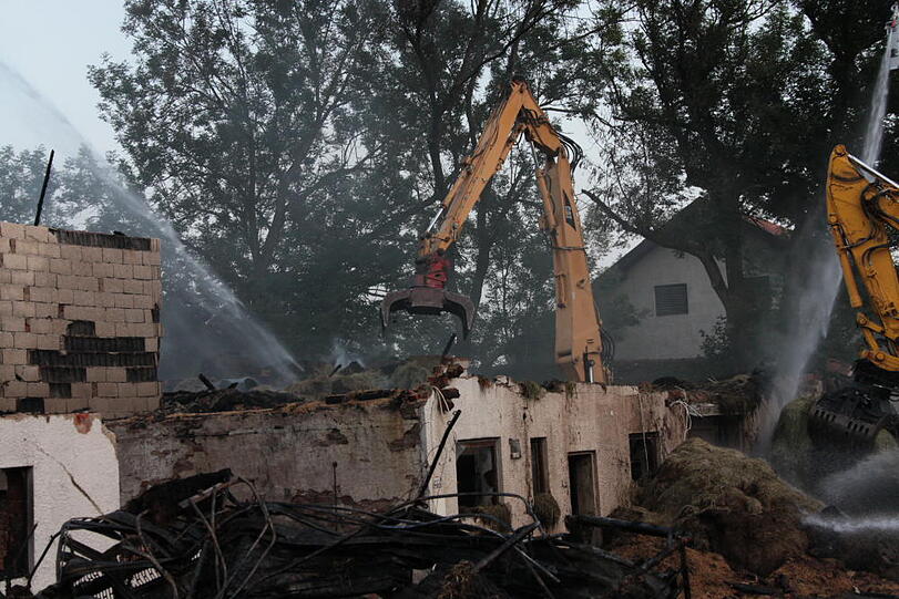 Aufräumarbeiten nach dem Mega-Brand in Heldenstein: Die Feuerwehr kann noch nicht aufatmen und kümmert sich um die Brandruine. Bei dem Feuer ist ein Schaden von etwa einer Million Euro entstanden.
