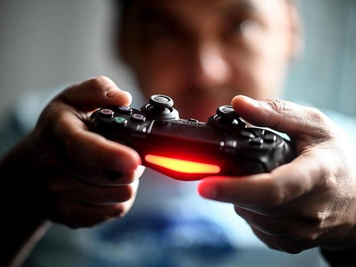 Sonys Playstation bring nach wie vor viel Geld in die Firmenkasse ein. Hier spielt ein junger Mann mit der Spielekonsole vor dem Fernseher.
