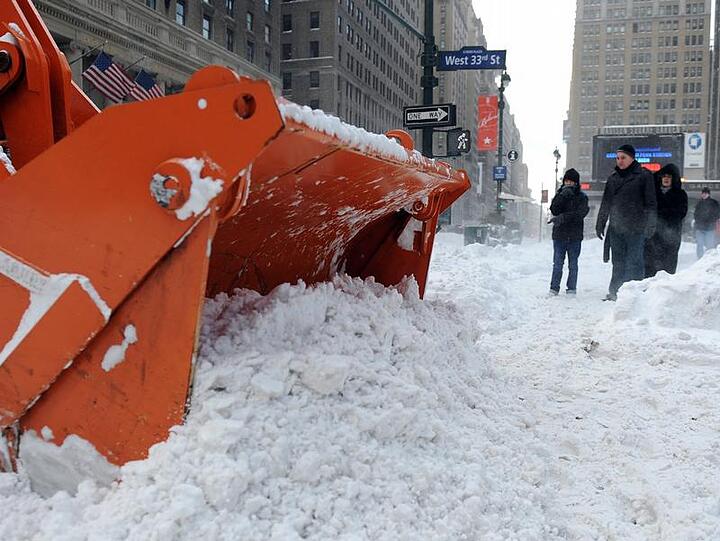 Ein Schneepflug räumt den Weg zur Penn Station - einem Durchgangsbahnhof im Westen Manhattans.