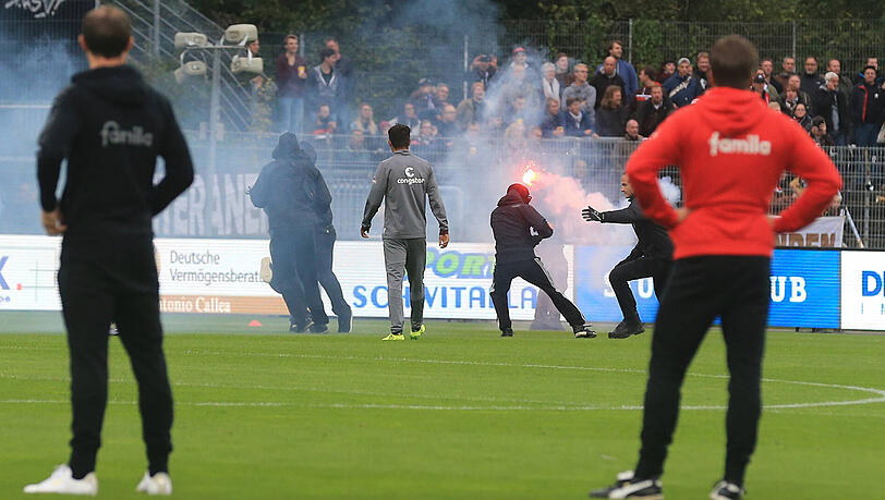 Die schwarz gekleideten Personen kamen aus dem Kieler Fanblock und versuchten, Fahnen und Spruchbänder der St.-Pauli-Anhänger in ihren Besitz zu bringen. Die schwarz gekleideten Personen kamen aus dem Kieler Fanblock und versuchten, Fahnen und Spruchbänder der St.-Pauli-Anhänger in ihren Besitz zu bringen.