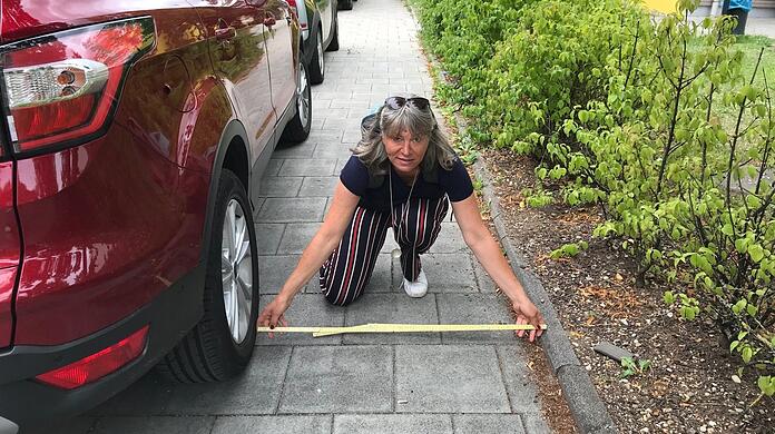 ÖDP-Stadträtin Sonja Haider mit ihrem Meterstab auf dem Gehweg vor der Kita an der Kirchmairstraße. Den parken Autos so zu, dass zu wenig Platz für Kinderwagen bleibt.