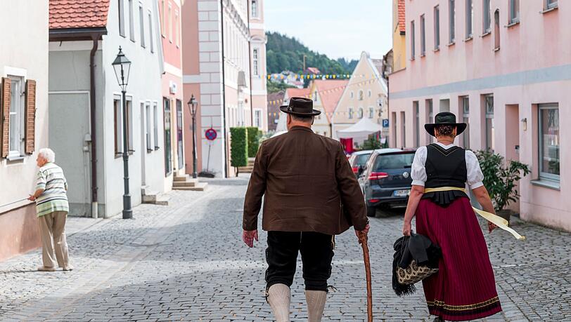 Zwei Personen in Tracht gehen durch die Gassen beim 29. Gredinger Trachtenmarkt.