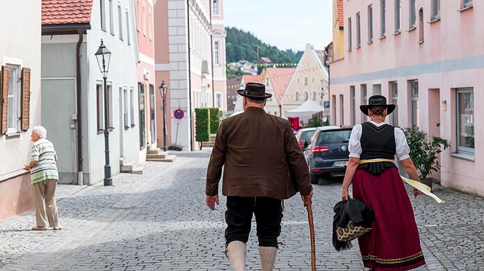 Zwei Personen in Tracht gehen durch die Gassen beim 29. Gredinger Trachtenmarkt.
