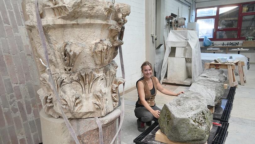 Die Steinmetzin und Restauratorin Clara Friedl neben den Trümmern der Burgfriedensäule - sie wird mit ihren Kollegen das zerstörte Denkmal wieder zusammenbauen.