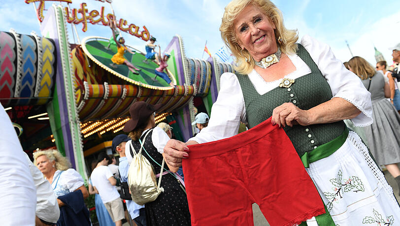 Die Betreiberin des Teufelsrades, Elisabeth "Lisi" Polaczy, steht mit einer Radlerhose vor dem Traditionsfahrgeschäft "Teufelsrad". Als Schutz vor Upskirting können sich Besucherinnen eine solche ausleihen. Die Betreiberin des Teufelsrades, Elisabeth "Lisi" Polaczy, steht mit einer Radlerhose vor dem Traditionsfahrgeschäft "Teufelsrad". Als Schutz vor Upskirting können sich Besucherinnen eine solche ausleihen.