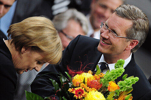 Die Kanzlerin, die Blumen, der Präsident:  Angela Merkel gratuliert Christian Wulff