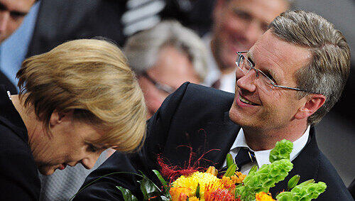 Die Kanzlerin, die Blumen, der Präsident: Angela Merkel gratuliert Christian Wulff Die Kanzlerin, die Blumen, der Präsident: Angela Merkel gratuliert Christian Wulff