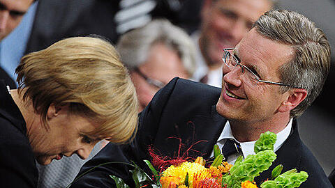 Die Kanzlerin, die Blumen, der Präsident:  Angela Merkel gratuliert Christian Wulff