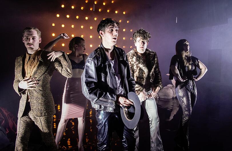 Timocin Ziegler als Marx (mit Hut und ohne Bart) und das Ensemble des Volkstheaters in &bdquo;Schöne neue Welt&ldquo;.