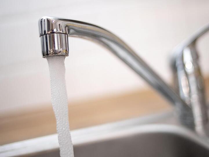 Ein laufender Wasserhahn. Foto: Marius Becker/dpa/Symbolbild