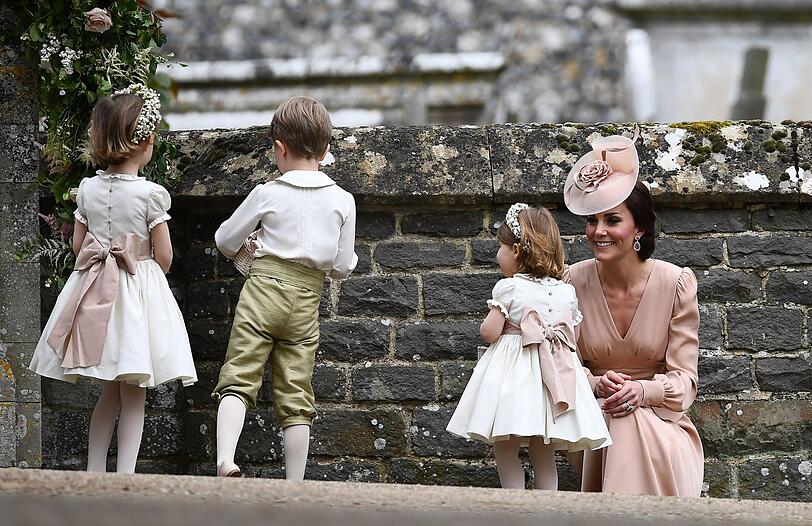 Die Schleife der kleinen Charlotte passt perfekt zum Kleid der Mama. Herzogin Kate kümmert sich nach der Hochzeit ihrer Schwester Pippa Middleton liebevoll um ihre Tochter.